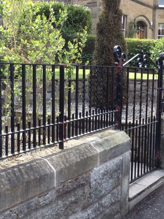 Railings with twisted bars and scrolled finials on the wall of a Victorian villa